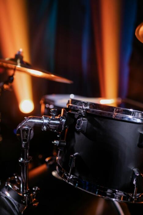Close-up of a snare drum, showing the drumhead texture, metal shell, and tension rods of a modern drum kit.