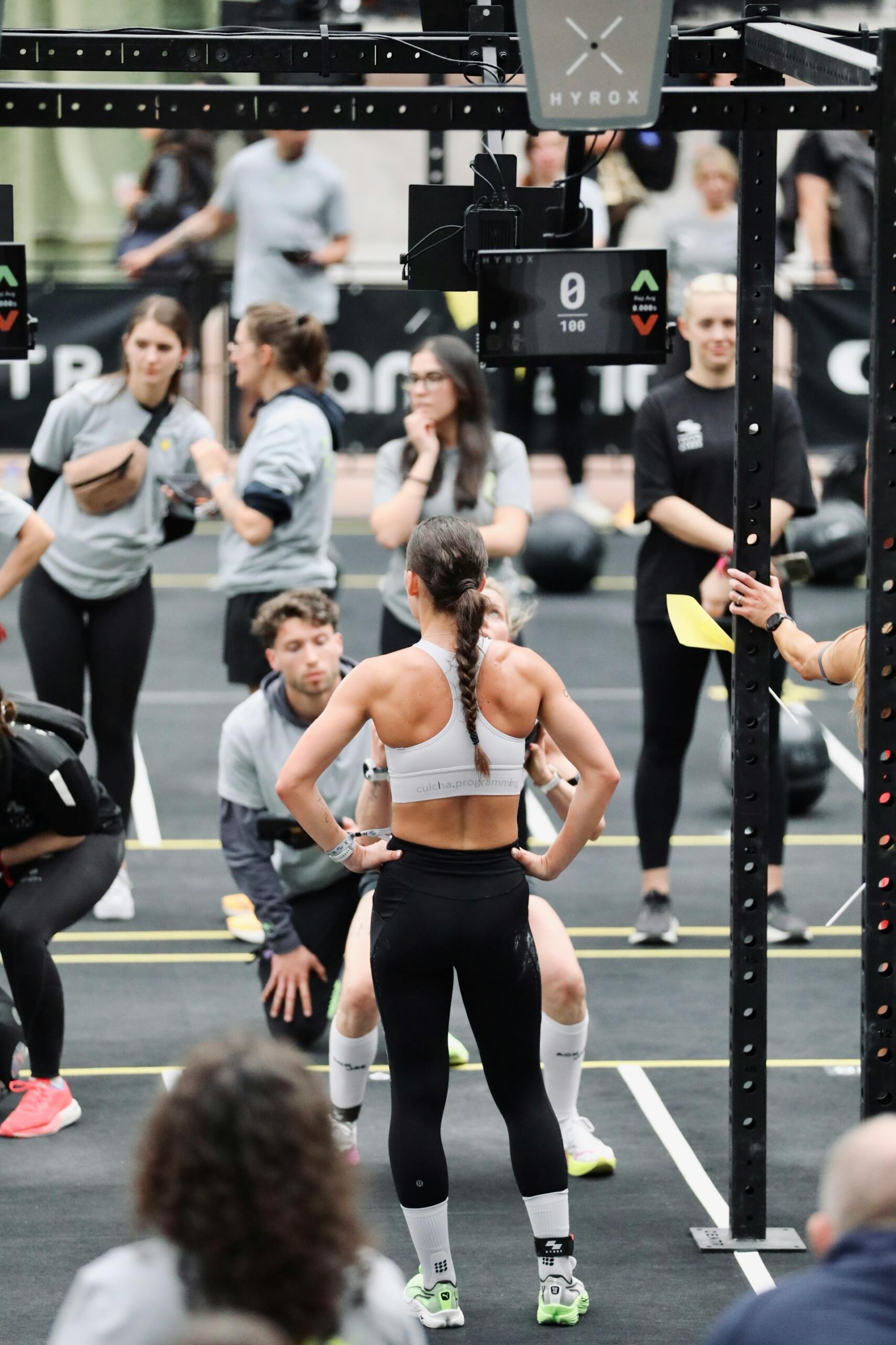 A group of athletes engaged in a fitness competition, focused on their training, with exercise equipment in the background.